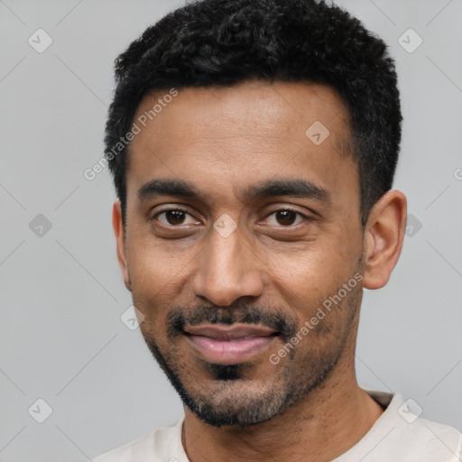 Joyful black young-adult male with short  black hair and brown eyes