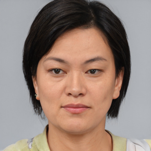 Joyful asian adult female with medium  brown hair and brown eyes