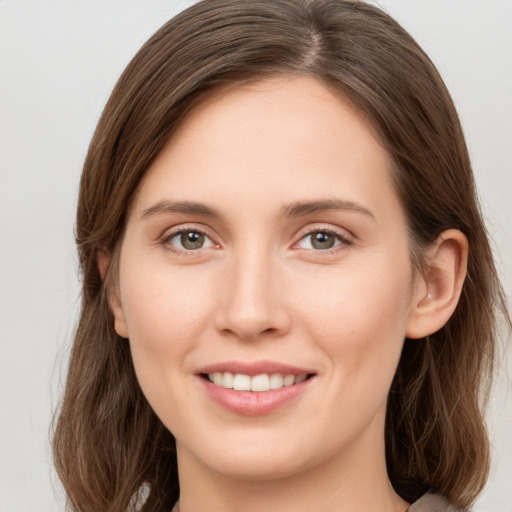 Joyful white young-adult female with medium  brown hair and grey eyes