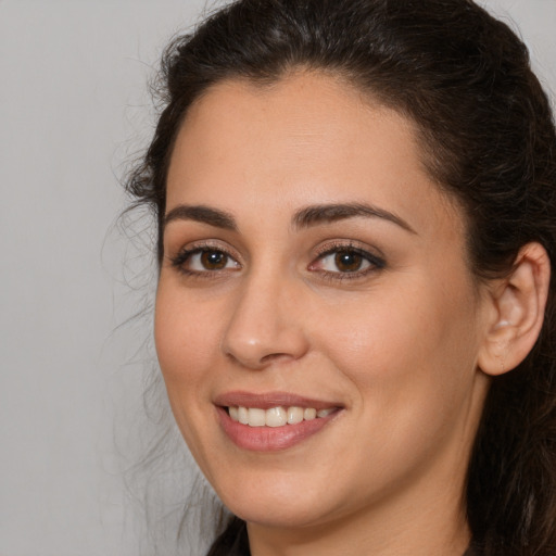 Joyful white young-adult female with long  brown hair and brown eyes