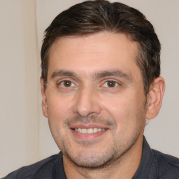 Joyful white adult male with short  brown hair and brown eyes