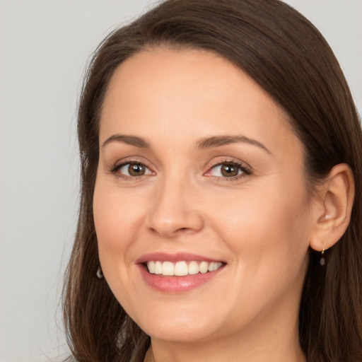 Joyful white young-adult female with long  brown hair and brown eyes