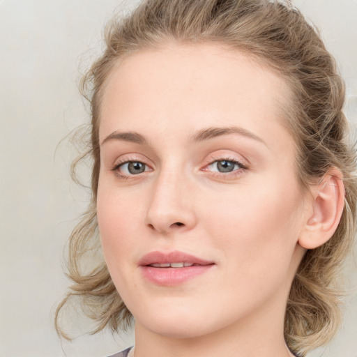 Joyful white young-adult female with long  brown hair and blue eyes