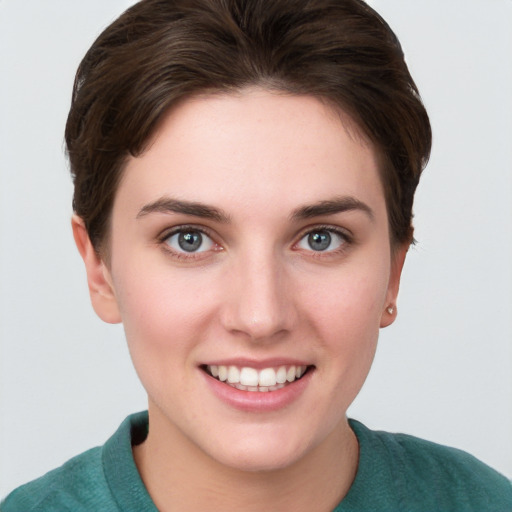 Joyful white young-adult female with short  brown hair and grey eyes