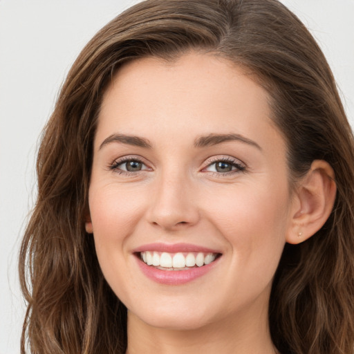 Joyful white young-adult female with long  brown hair and green eyes