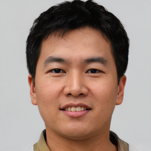 Joyful asian young-adult male with short  black hair and brown eyes