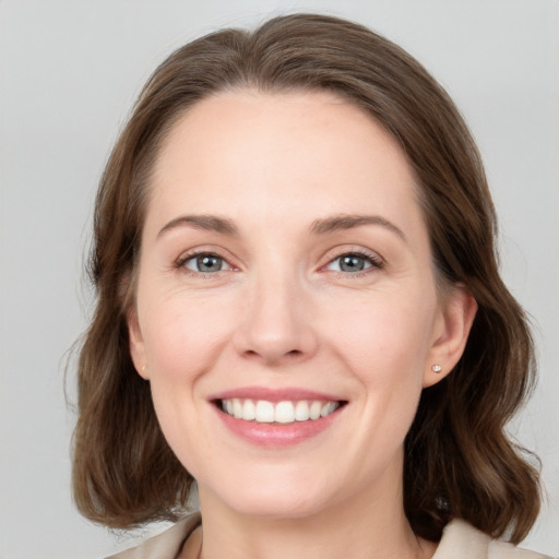 Joyful white young-adult female with medium  brown hair and grey eyes