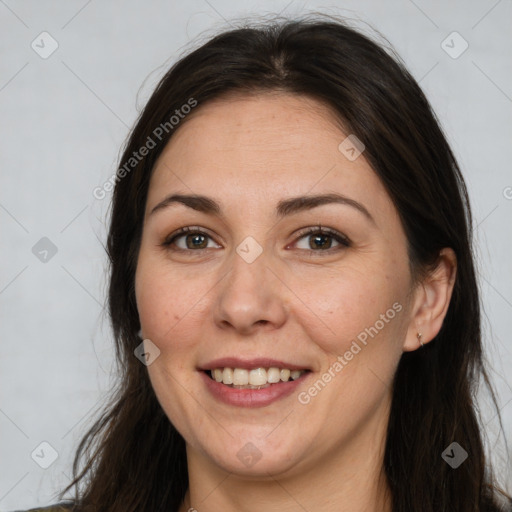 Joyful white adult female with long  brown hair and brown eyes