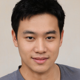 Joyful asian young-adult male with short  black hair and brown eyes