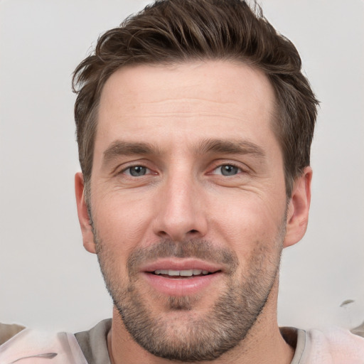 Joyful white young-adult male with short  brown hair and grey eyes