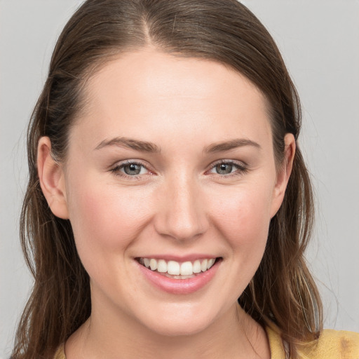 Joyful white young-adult female with long  brown hair and grey eyes