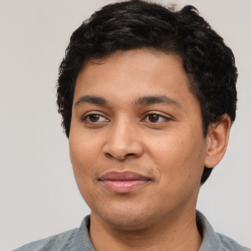 Joyful latino young-adult male with short  black hair and brown eyes