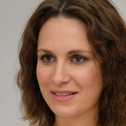 Joyful white adult female with long  brown hair and green eyes