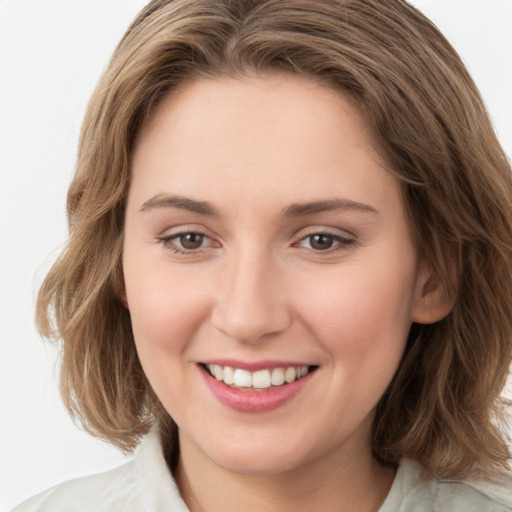 Joyful white young-adult female with medium  brown hair and green eyes