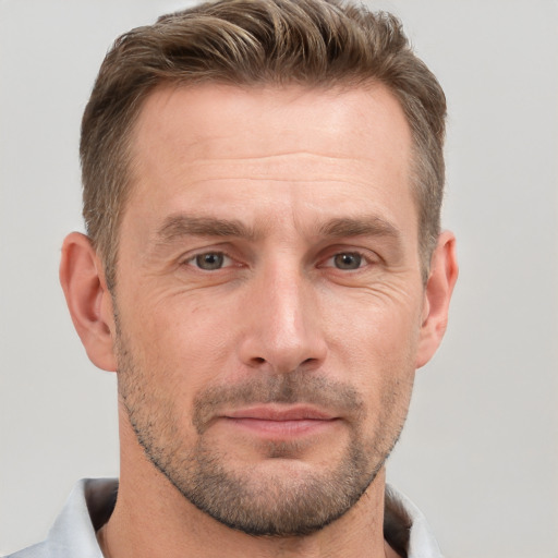 Joyful white adult male with short  brown hair and grey eyes