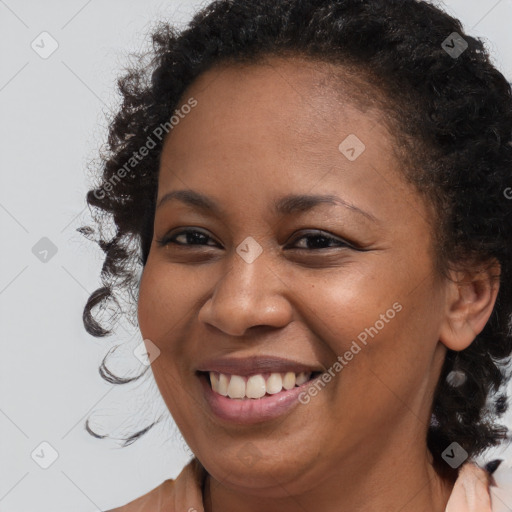 Joyful black young-adult female with long  brown hair and brown eyes