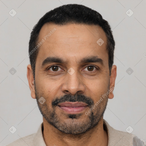 Joyful latino adult male with short  black hair and brown eyes