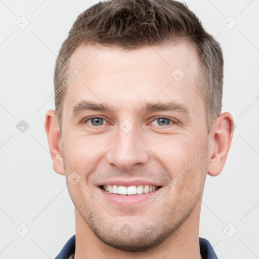 Joyful white young-adult male with short  brown hair and grey eyes