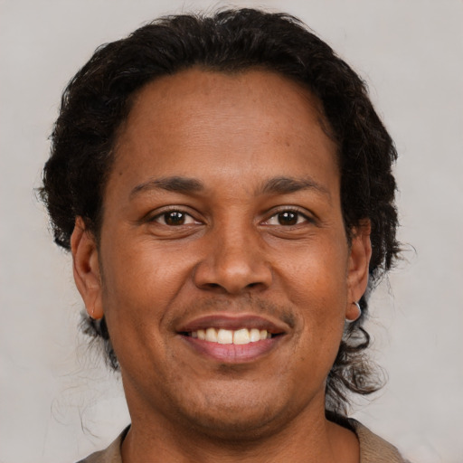 Joyful black adult male with short  brown hair and brown eyes