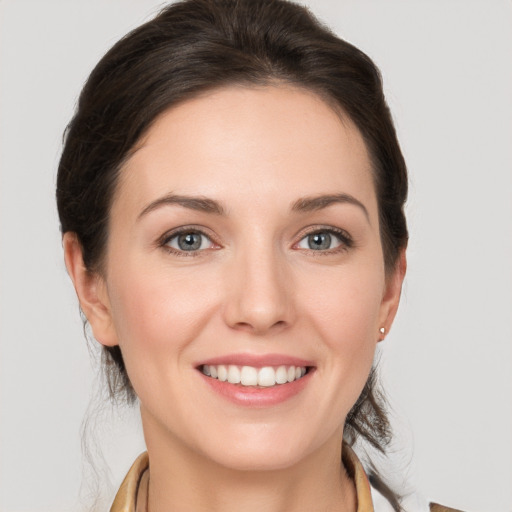 Joyful white young-adult female with medium  brown hair and grey eyes