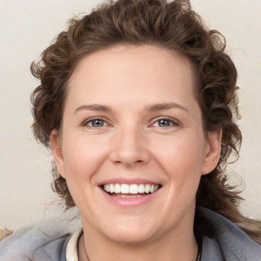 Joyful white young-adult female with medium  brown hair and blue eyes