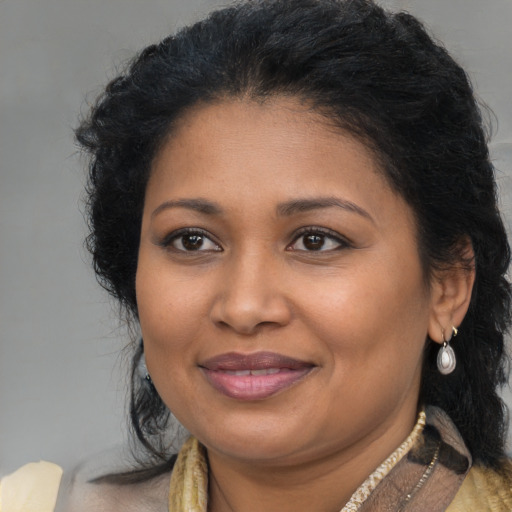 Joyful black adult female with long  brown hair and brown eyes