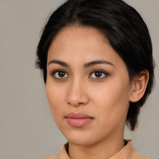 Joyful latino young-adult female with medium  brown hair and brown eyes