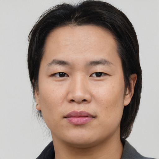 Joyful asian young-adult male with medium  brown hair and brown eyes