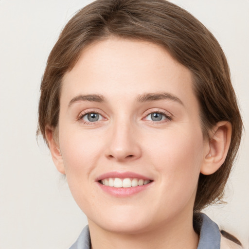 Joyful white young-adult female with medium  brown hair and grey eyes