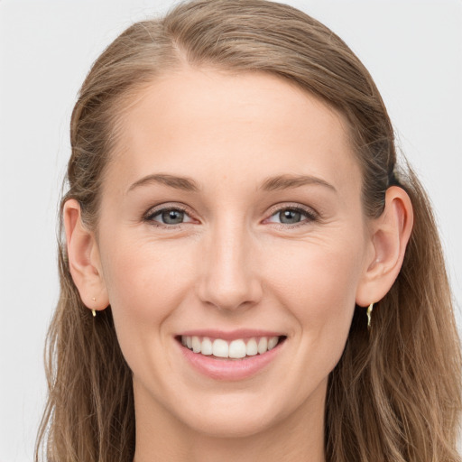 Joyful white young-adult female with long  brown hair and blue eyes