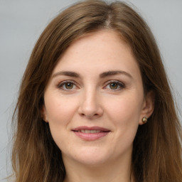 Joyful white young-adult female with long  brown hair and grey eyes