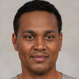 Joyful black young-adult male with short  black hair and brown eyes