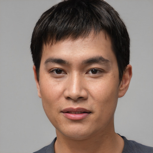 Joyful asian young-adult male with short  black hair and brown eyes