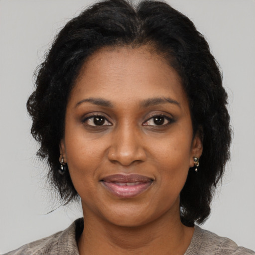 Joyful black adult female with medium  brown hair and brown eyes