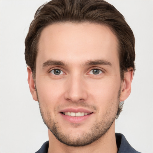 Joyful white young-adult male with short  brown hair and grey eyes