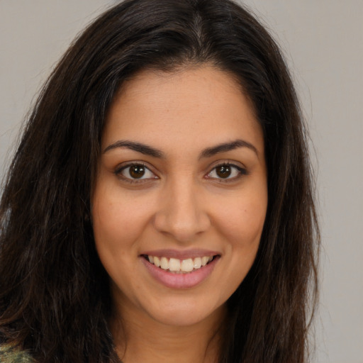 Joyful latino young-adult female with long  brown hair and brown eyes