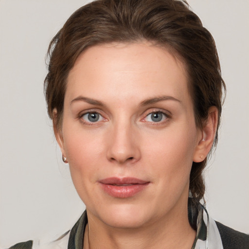 Joyful white young-adult female with medium  brown hair and grey eyes