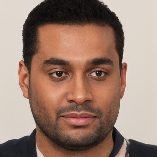 Joyful black young-adult male with short  brown hair and brown eyes