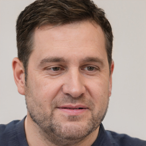 Joyful white adult male with short  brown hair and brown eyes