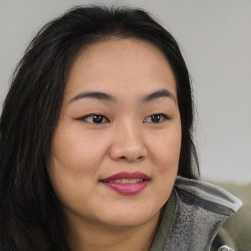 Joyful asian young-adult female with long  brown hair and brown eyes