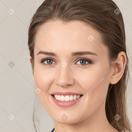 Joyful white young-adult female with medium  brown hair and grey eyes