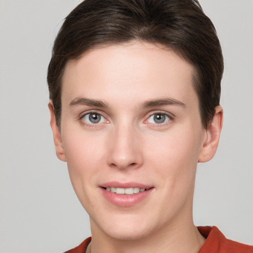 Joyful white young-adult female with short  brown hair and grey eyes