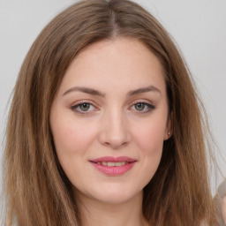 Joyful white young-adult female with long  brown hair and green eyes