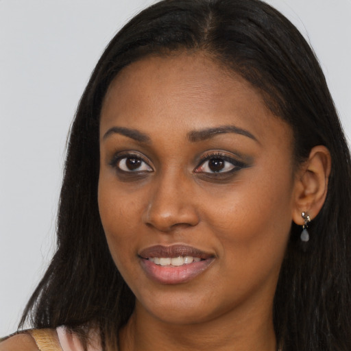Joyful black young-adult female with long  brown hair and brown eyes