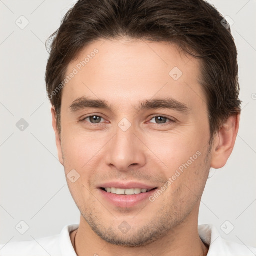 Joyful white young-adult male with short  brown hair and brown eyes