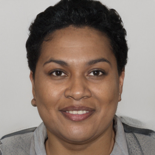 Joyful black young-adult female with short  black hair and brown eyes
