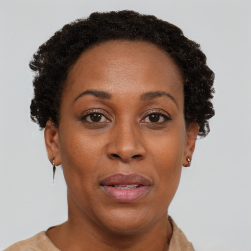 Joyful black adult female with short  brown hair and brown eyes