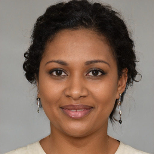 Joyful black young-adult female with medium  brown hair and brown eyes
