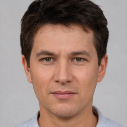 Joyful white adult male with short  brown hair and brown eyes