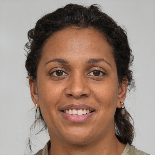 Joyful black adult female with medium  brown hair and brown eyes